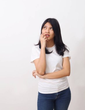 Asyalı düşünceli bir kadının beyaz arka planda tek başına dikilip bakışları..