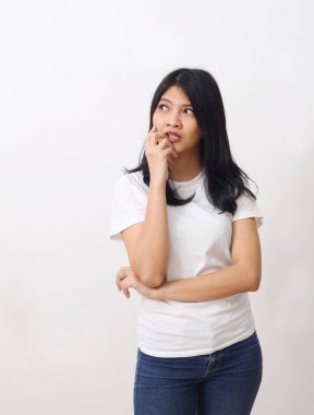 Asyalı düşünceli bir kadının beyaz arka planda tek başına dikilip bakışları..