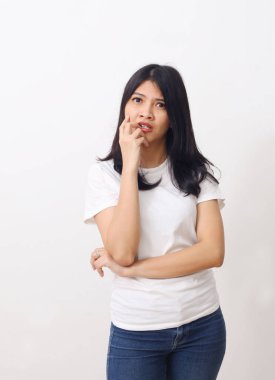 Asyalı düşünceli bir kadının beyaz arka planda tek başına dikilip bakışları..