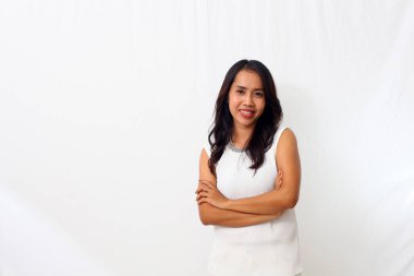 Güzel genç Asyalı kız kollarını kavuşturup kameraya bakarken gülümsedi. Beyaz arkaplanda izole