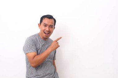 Asyalı bir adamın boş uzaya bir şey doğrulttuğu portresi. Kopyalama alanı ile beyaza izole edilmiş