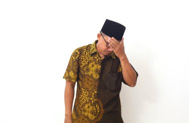 Asyalı insanlar üzgün ve baş ağrısından dolayı ellerini sıkarak başlarını sıkıyorlar. Stres ve migren kavramı.