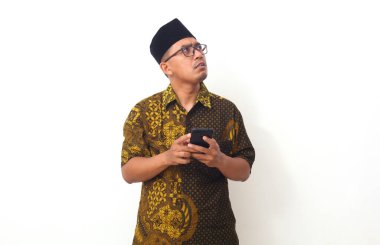 Cep telefonunu tutan Asyalı adamın düşünceli yüzü. Beyaz arkaplanda izole