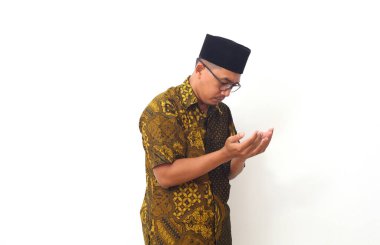 Asyalı Müslüman adam dua etmek için iki elini de kaldırdı. Beyaz arkaplanda izole