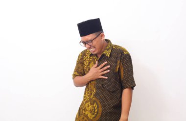 Asyalı adam acı çekiyor ve elini göğsüne dokunmak için kullanıyor. Kalp krizi belirtilerini kontrol etmek için. Akıl sağlığı konsepti.