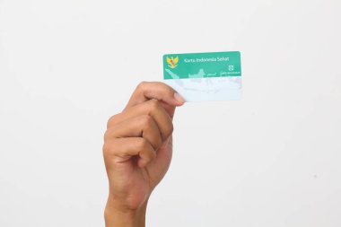 Yogyakarta, Indonesia - Mar 10, 2021 : Hand holds Kartu Indonesia Sehat(KIS) or Indonesia Health Card, Health Insurance card from the Government of Indonesia