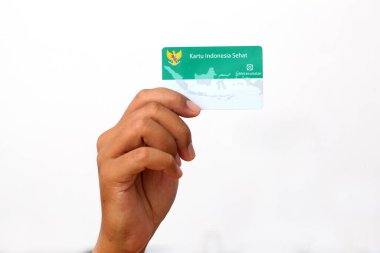 Yogyakarta, Indonesia - Mar 10, 2021 : Hand holds Kartu Indonesia Sehat(KIS) or Indonesia Health Card, Health Insurance card from the Government of Indonesia