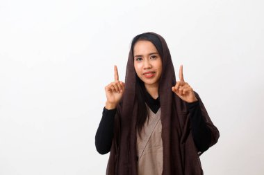 Duvak takan mutlu Asyalı Müslüman kadın portresi ya da boş uzayda bir şey gösteren ya da sunan tesettür. Kopya alanı ile beyaz arkaplanda izole