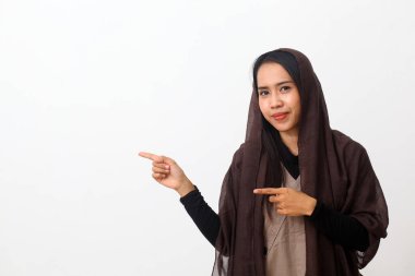 Duvak takan mutlu Asyalı Müslüman kadın portresi ya da boş uzayda bir şey gösteren ya da sunan tesettür. Kopya alanı ile beyaz arkaplanda izole