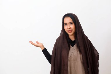 Duvak takan, tesettürlü, tesettürlü, yanında bir şey sunan mutlu Asyalı Müslüman kadının portresi. Kopya alanı ile beyaz arkaplanda izole