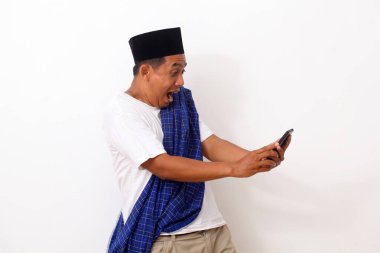 Elinde telefon tutarken Asyalı bir adam şaşırdı. Beyazda izole edilmiş. Ramazan kavramı