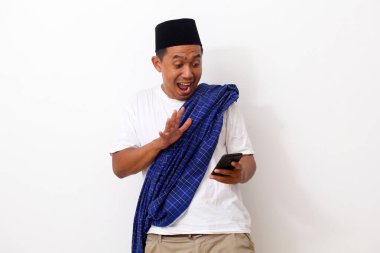 Cep telefonuna bakarken mutlu ve şaşırmış Asyalı bir adam. Beyaz arkaplanda izole