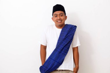 Ramazan kıyafetli mutlu Asyalı adam ayakta ve gülümsüyor. Beyaz arkaplanda izole
