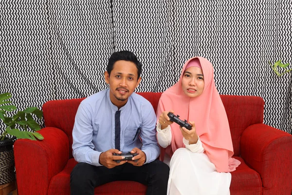 Pasangan Muslim Asia Duduk Sofa Merah Saat Bermain Video Game — Stok Foto