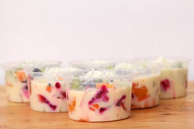 Tahta arka planda bir kase sağlıklı taze meyve salatası.