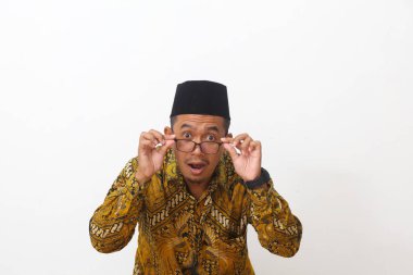 Vay canına! Ağzı açık, bardaklara dokunan Asyalı genç bir adam. Beyaz arkaplanda izole