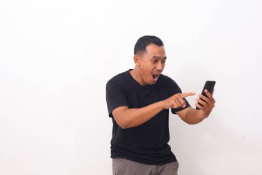 Cep telefonuna bakıp işaret eden Asyalı adamın şok olmuş yüzü. Beyaz arkaplanda izole
