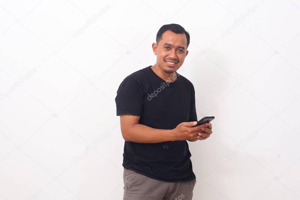 Portrait of happy Asian man while holding his cellular phone. Isolated on white background