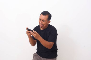 Cep telefonuyla oyun oynarken Asyalı bir adamın hayal kırıklığına uğramış yüzü. Beyaz arkaplanda izole