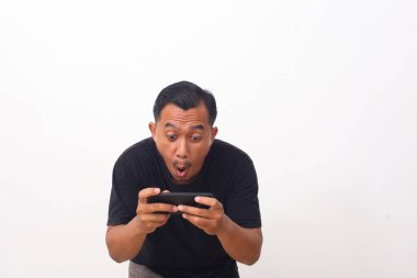 Cep telefonuna bakarken Asyalı adamın şok olmuş yüzü. Beyaz arkaplanda izole