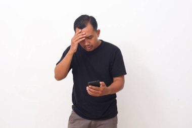 Akıllı telefondaki programla Asyalı adam ağlıyor ve üzülüyor. Beyaz arkaplanda izole