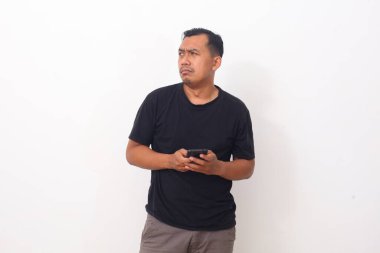 Asyalı Adam, yan yan bakarken akıllı telefondan izlediği programdan nefret eder ve iğrenir. Beyaz arkaplanda izole