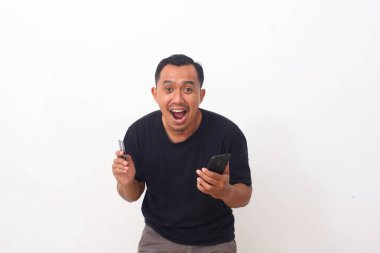 Cep telefonuna bakarken Asyalı adamın şok olmuş yüzü. İnternetten alışveriş konsepti. Beyaz arkaplanda izole