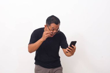 Cep telefonuna bakarken Asyalı adamın şok olmuş yüzü. Beyaz arkaplanda izole