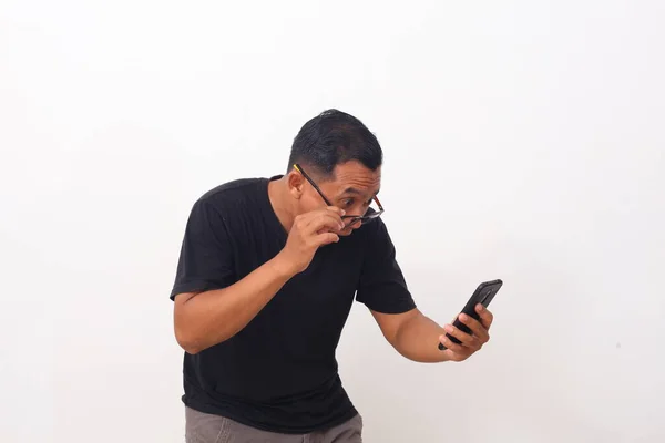 携帯電話を見ながら アジア人の男のすごいとショックを受けた顔 白地に隔離された — ストック写真