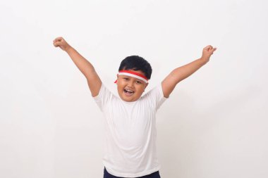 Yumruğunu sıkarken ayakta duran mutlu Asyalı çocuk portresi. Beyaz arkaplanda izole