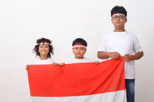 印度尼西亚儿童举着印度尼西亚国旗 独立日的概念 因白人背景而被隔离 — 图库照片