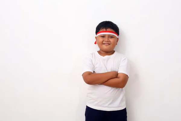 白い背景を背景に立ちながら 赤い白いリボンをつけた幸せなアジアの少年の肖像画 — ストック写真