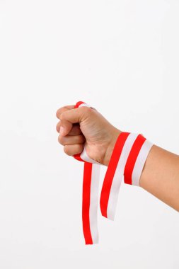 Bir insan eli, Endonezya bayrağının sembolü olarak kırmızı beyaz kurdele tutar. Beyaz arkaplanda izole