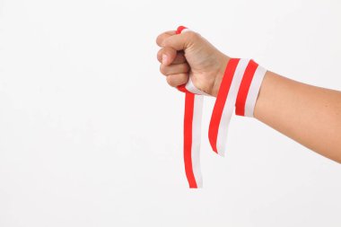 Bir insan eli, Endonezya bayrağının sembolü olarak kırmızı beyaz kurdele tutar. Beyaz arkaplanda izole