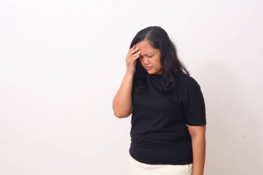 Güzel Asyalı kız başını tutarken ayakta duruyor. Baş ağrısı. Kopyalama alanı ile beyaz arkaplanda izole