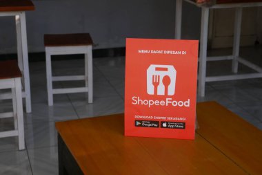 Yogyakarta, Endonezya - 6 Temmuz 2021: Ahşap masada ShopeFood tabelası. ShopeeFood, Shopee 'de yemek dağıtım hizmeti sunan en yeni ürün.