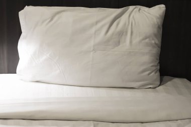 Yatak odasındaki beyaz yatakta yastıklar.