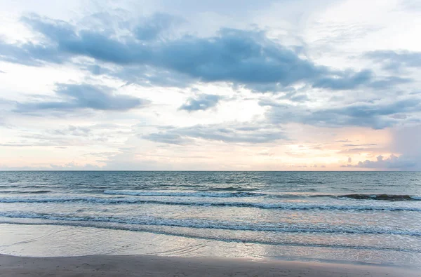 Deniz alacakaranlıkta, güneş batıyor, dalgalar soluk