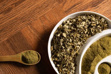 Ahşap kaşıkta moringa tozu - kurutulmuş moringa yaprakları - moringa oleifera - arka plan