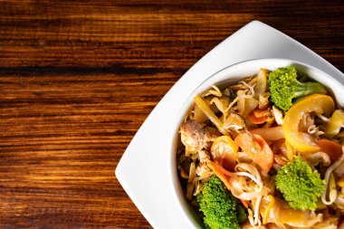 Çeşitli Asya yemekleri, koyu kırsal ahşap arka plan. Çin yemekleri. Etli Asya pirinci, mezeler, Çin buğulamalı çörekler. Mesaj için yer var. Üst Manzara. Asya tarzı