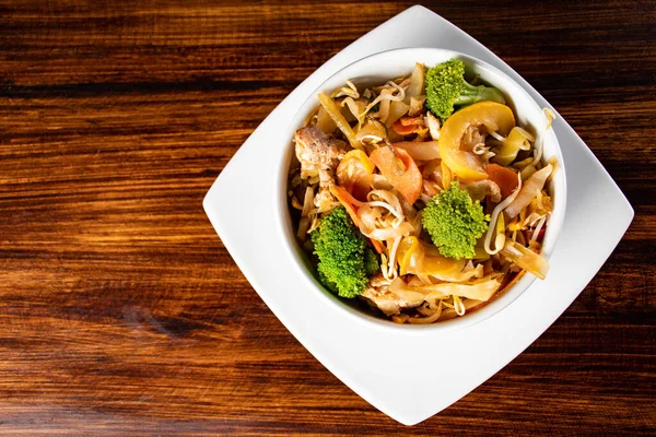 Çeşitli Asya yemekleri, koyu kırsal ahşap arka plan. Çin yemekleri. Etli Asya pirinci, mezeler, Çin buğulamalı çörekler. Mesaj için yer var. Üst Manzara. Asya tarzı