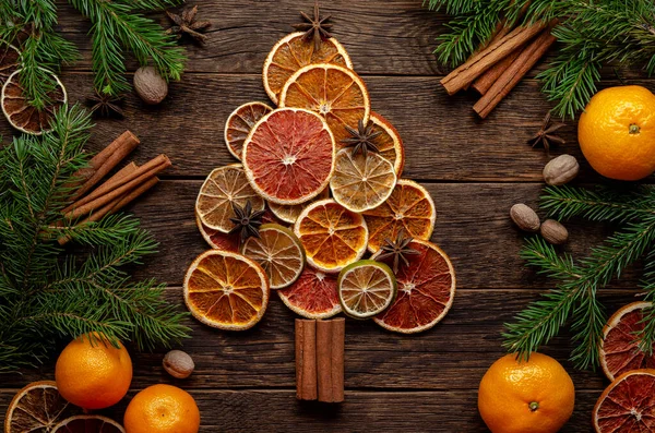 Kurutulmuş turunç ve tarçından yapılmış Noel ağacı, ahşap zemin üzerinde anason. Portakal, kireç, kırmızı turuncu — Stok fotoğraf