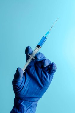 Mavi arka plan, ilaç ve uyuşturucu üzerinde Coronavirus aşısı ile şırınga