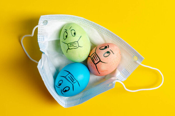 Easter eggs in a protective medicine mask. Easter quarantine concept.