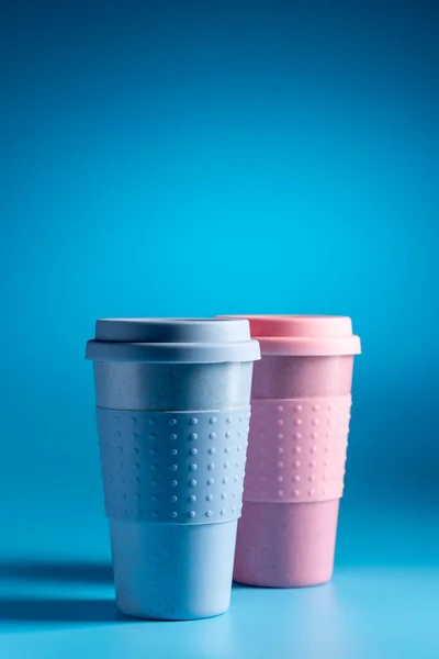 Reusable coffee cup on light blue background. Bamboo