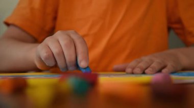 Küçük çocuk kağıda balmumu çiziyor. Yaklaş. 0 derece açı.