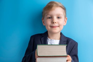 Elinde kitap tutan küçük bir okul çocuğu. Okul kavramı.