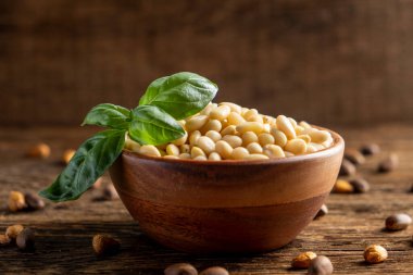 Tahta arka planda fesleğen ve çam fıstığı.