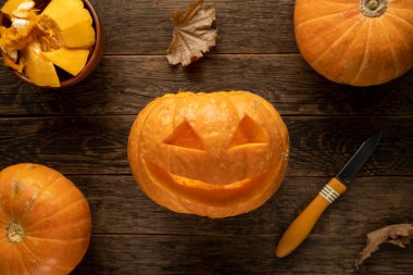 Cadılar Bayramı için balkabağı oyan bir kadın.