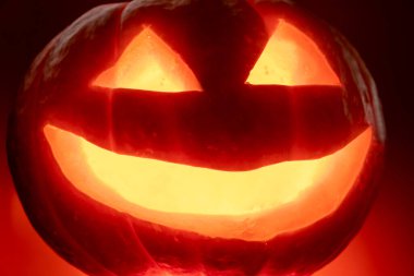 Cadılar bayramı balkabağı turuncu arka planda mumla karanlıkta